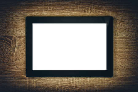 Digital tablet with white blank screen as copy space on wooden background.の写真素材