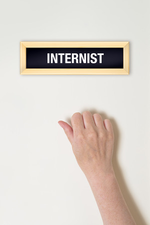 Female hand is knocking on Internist door for a medical examの写真素材