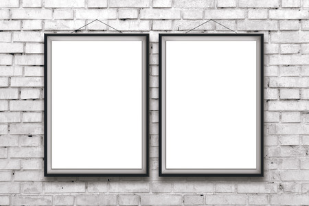 Two blank vertical painting or posters in black frame hanging on white brick wall. Painting proportions match international paper size A.の写真素材