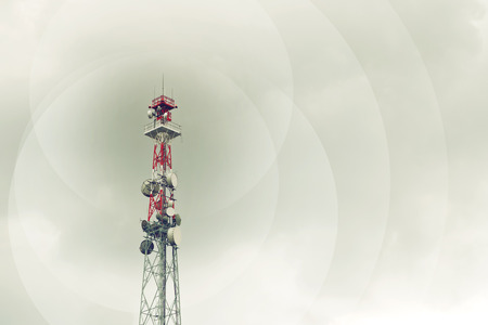 Red and white communication tower with GSM antenna transmitters.の写真素材