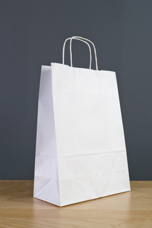 White Paper Shopping Bag on Wooden Retail Store Table.の写真素材
