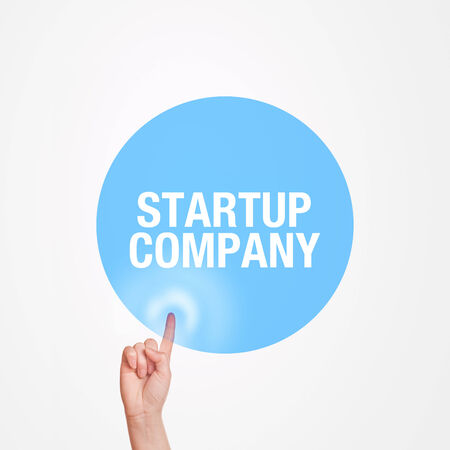 Cuacasian female hand pushing Startup Company touchscreen button with index finger.の写真素材