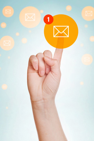 Checking E-mail Inbox, caucasian female hand pushing e-mail icon on virtual display.の写真素材
