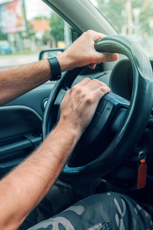 Nervous male driver pushing car horn in traffic rush hour, close up with selective focus on hand on...