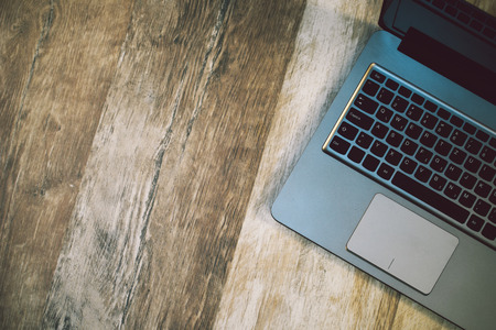 Modern laptop computer on rustic wooden background as copy space, top viewの写真素材