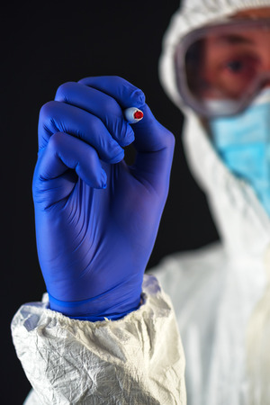 Scientist in protective clothes writing with red marker felt tip penの写真素材