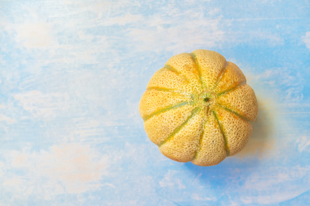 Cantaloupe melon on rustic wooden table, top view of whole fruit