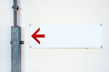 Blank direction sign with red arrow on the wall as copy spaceの写真素材