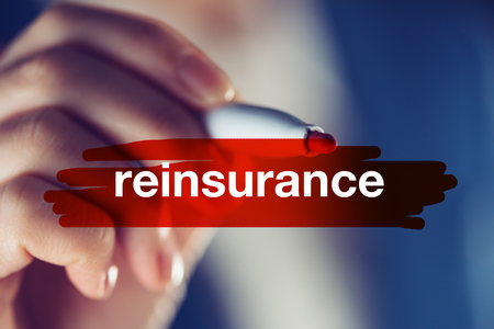 Reinsurance business concept, businesswoman highlighting word with red marker penの写真素材