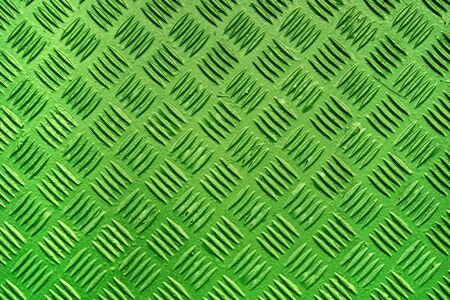 Green metal surface background with repeating diamond pattern, old used painted industrial metallic plate textureの写真素材
