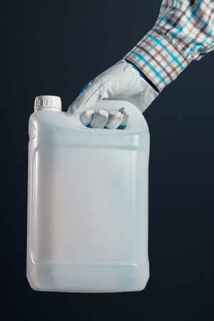 Unrecognizable male farmer with unlabeled plastic tank canister containing pesticides for plant processing in agricultureの写真素材
