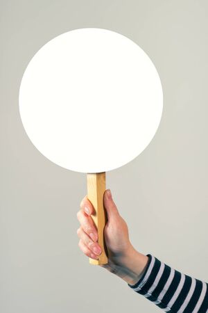 Female hand holding blank mock up banner sign as copy space for quotation text or graphic designの写真素材