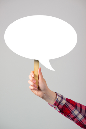 Female hand with speech bubble balloon as copy space for lifestyle and communication themes