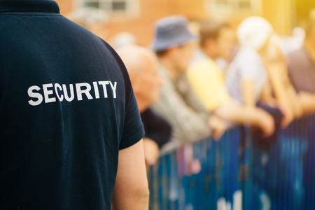 Member of security guard team working on public event, unrecognizable male person from behind