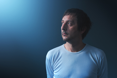 Hopeless man looking up to the light, sad and disappointed adult male person in hope conceptの写真素材