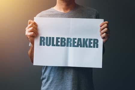 Rulebreaker attitude, person who breakes the rules concept with male holding posterの写真素材
