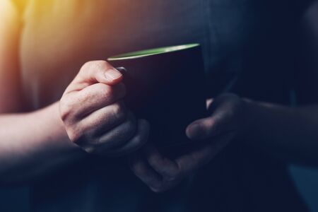 Woman drinking morning coffee, close up of female hands with coffee cupの写真素材