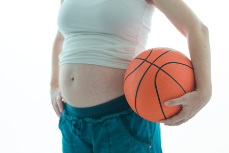 Pregnant woman with basketball isolated on white backgroundの写真素材