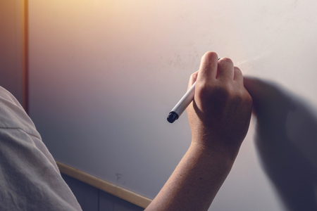 Hand writing on whiteboard surface - office, business and education conceptの写真素材