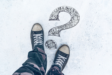 Question mark on the road and sneakers, wondering and asking questionsの写真素材