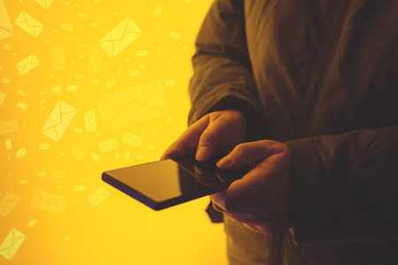 Woman using smartphone on street at night, close up of female hands typing on mobile phoneの写真素材
