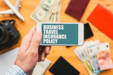 Business travel insurance policy online mobile app. Man holding smartphone with mock up application screen related to holiday vacation journey trip.の写真素材