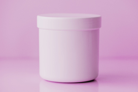 Cosmetic cream plastic jar with blank surface as copy space, minimalistic pastel color toned imageの写真素材