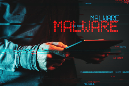 Malware concept with person using tablet computer, low key red and blue lit image and digital glitch effectの写真素材