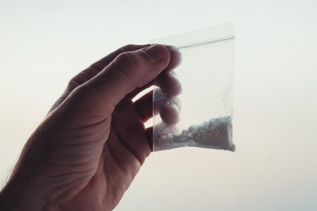 Criminology expert collecting drug evidence at crime scene, close up of handの写真素材