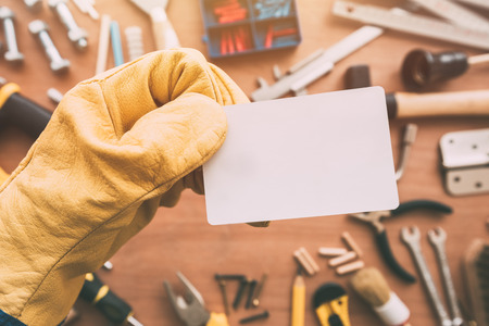 Repairman blank business card as copy space over workshop table with maintenance and fix-up project...
