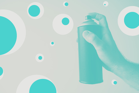 Duotone image of graffiti artist holding color spray can about to create some street artwork on the blank wallの写真素材