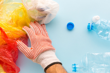 Worker sorting plastic garbage for recycling, conceptual image