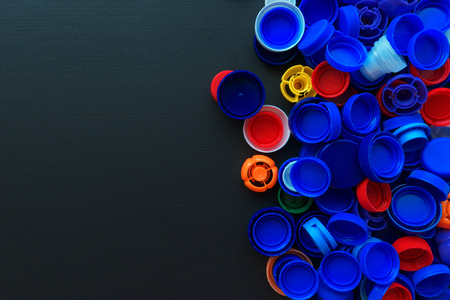 Recycled plastic bottle caps in various colors, top view