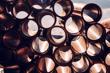Plastic sewer pipes on construction site for system repairing stacked and ready to be installedの写真素材