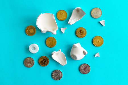 Cryptocurrency coins and broken piggy coin bank, savings and home finances concept