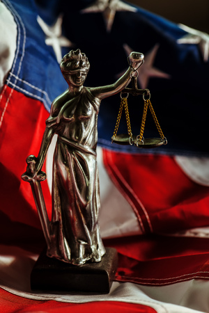 Law and Justice in United States of America, statue of Lady Justice with USA flag in background, selective focusの写真素材