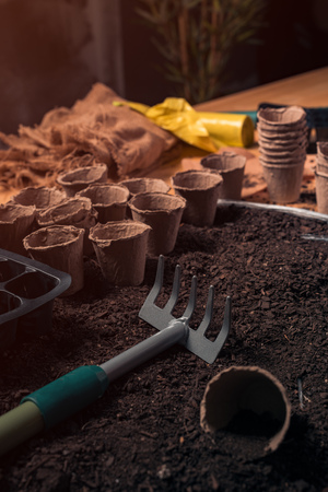 Organic farming rake and pots in soil, ready for sowing and planting of homegrown produce season in springの写真素材