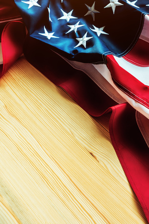 USA flag crumpled on wooden background, american banner with embroidered stars and stripesの写真素材