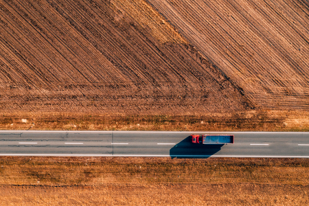 Aerial view of truck on the road through plain countryside from drone povの写真素材