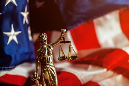 Law and Justice in United States of America, statue of Lady Justice with USA flag in background, selective focusの写真素材