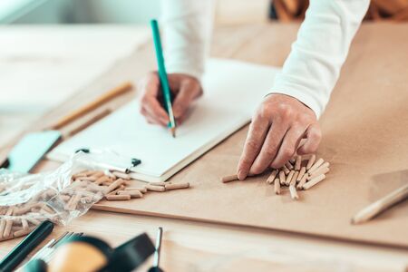 Female carpenter working with wooden dowels in carpentry woodwork workshop, selective focusの写真素材
