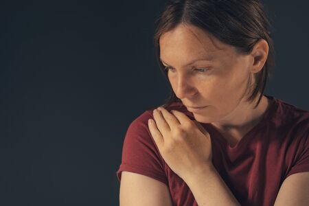 Sensual melancholic female portrait, no makeup and no retouching. Adult caucasian woman looking let...