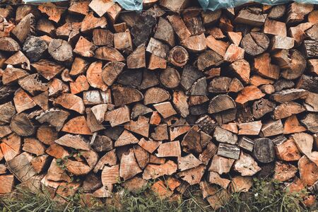 Stacked wooden logs, chopped firewood heap as background