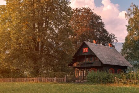Alpine style traditional countryside house in summer sunset