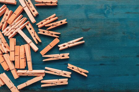 Wooden clothes pegs on wooden plank, top view