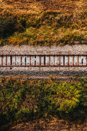 Old railroad track through countryside in autumn, aerial view from drone povの写真素材