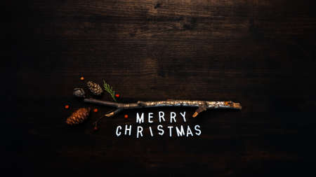 Merry Christmas text flat lay top view on dark wooden background with copy space includedの写真素材