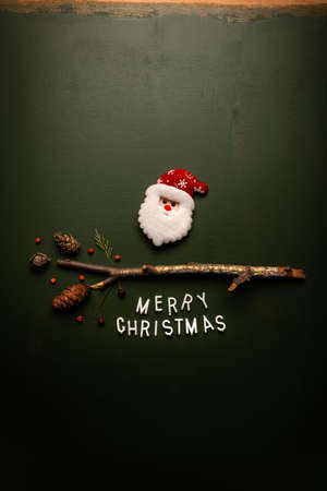Merry Christmas text flat lay top view with Santa Claus on green background, xmas holiday conceptual imageの写真素材