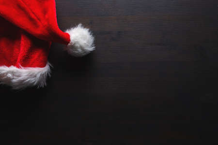 Santa Claus hat on dark wooden table as copy space, flat lay top viewの写真素材