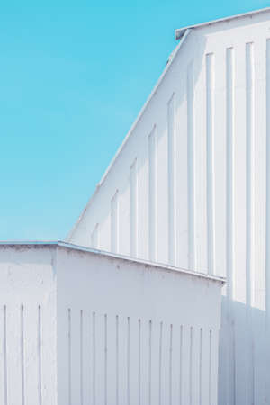Urban abstract, white concrete wall against blue sky. Geometry and shapes in architectural minimalism.の写真素材